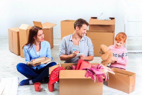 Professional movers carrying furniture on a narrow Holloway staircase