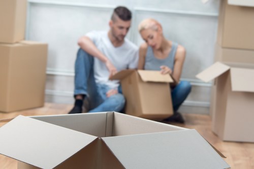 Professional movers carrying furniture in a North London flat