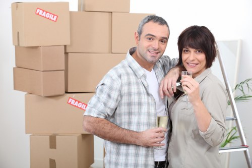 Professional movers carrying furniture down stairs in Holloway